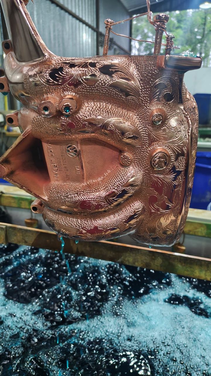 Peça com gravação artística saindo do banho de cobre